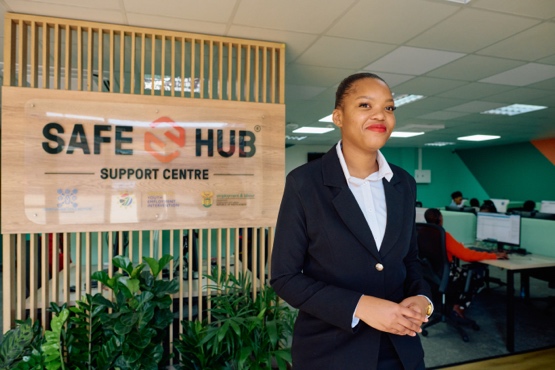 Khanyisile standing in front of the Safe-Hub Support Centre sign